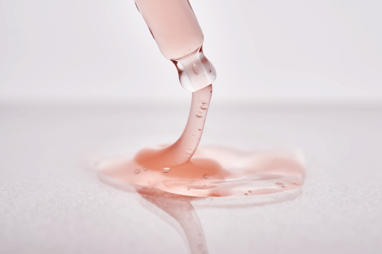 Pipette with a viscous pink cosmetic close-up.